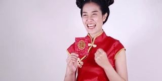 女人穿着旗袍，打开红包，寓意春节快乐