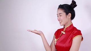 女子身着红色旗袍，手掌张开，寓意春节快乐视频素材模板下载