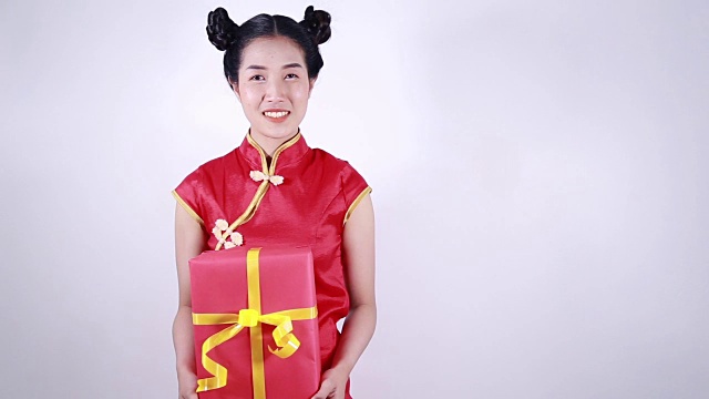 年轻女子拿着红色礼盒，寓意春节快乐