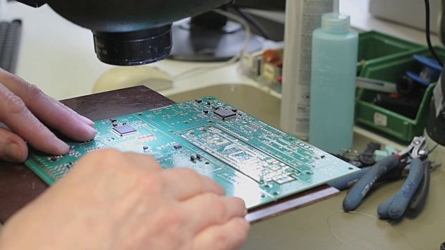 工程师用烙铁修理印刷电路板