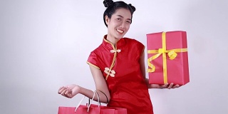 快乐的女人拿着购物袋和红色礼盒在概念中国新年庆祝