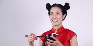 快乐的女人穿着中国旗袍，带着筷子和碗