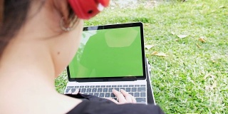 特写女性的手键盘笔记本电脑使用短信指向网络绿色屏幕和快乐的女人听音乐