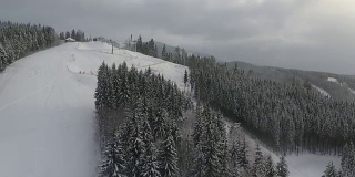 滑雪者和滑雪板运动员从滑雪场的斜坡上滑下来。