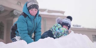 孩子们在雪山上玩耍，扔雪和雪片。阳光明媚的一天。新鲜的空气里充满了乐趣和游戏。