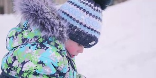 一个小孩在雪里玩。一个晴朗的冬日。新鲜的空气里充满了乐趣和游戏。