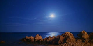 史诗般的月亮从海上升起。有一个月球轨道，星星和陨星
