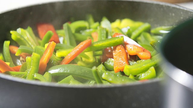 用平底锅搅拌新鲜蔬菜