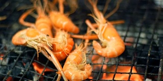虾用钳子烤好，翻过来。夜市，芭堤雅，宗田。泰国菜。市场上有亚洲异国菜肴