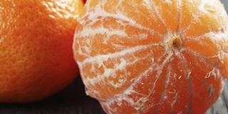 成熟的橘子在木桌上剥皮