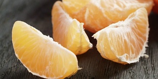 成熟的橘子在木桌上剥皮