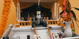 泰国园林中的传统佛坛装饰精美，有鲜花和各种象征人物