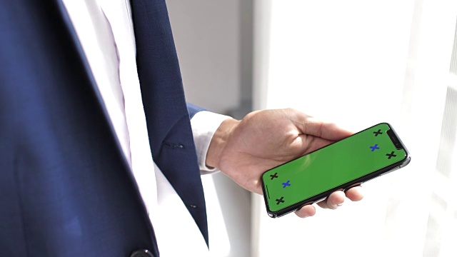 人的手用绿屏手机，iPhone X