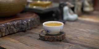 用慢动作将泡好的绿茶从玻璃茶壶中倒入白色陶瓷杯中