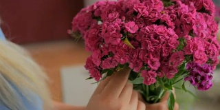 专业花匠在车间为花束准备粉红色的土耳其康乃馨