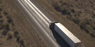 航拍:半卡车集装箱拖车穿越犹他州的荒芜乡村