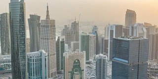 在卡塔尔首都多哈的商业中心，日落前的摩天大楼在天际线上缓缓落下