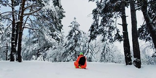 一个拿着相机的人正在拍摄冬天雪地里的森林。