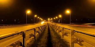 公路交通车辆在夜间时间流逝。汽车行驶在道路上的桥晚上延时。4 k UHD