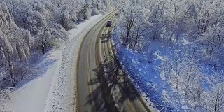 汽车在白雪覆盖的森林里行驶