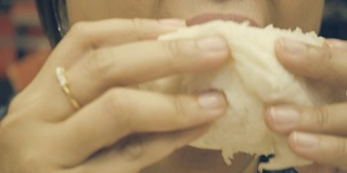 特写:一名亚洲女子正在吃一个馒头