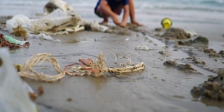 小女孩在被污染的垃圾海滩上玩耍