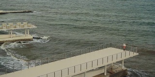 一个女人站在波涛汹涌的海面上