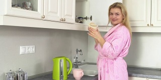 年轻女子在家庭浴袍拿一罐茶，享受它的气味