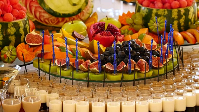 婚礼自助餐桌上各种新鲜水果。水果和浆果婚礼餐桌装饰。自助餐接待，果酒，香槟。婚礼装饰桌子