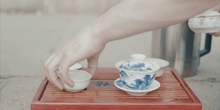 传统的中国茶道。视频。男子手套中国茶杯特写。中国的饮茶仪式。倒茶喝