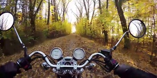 4 k编译视频。神奇的摩托车骑向金色的日落在神奇的森林道路上，宽阔的视角的骑手。永远经典的巡洋舰/直升机!