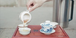 传统的中国茶道。视频。男子手套中国茶杯特写。中国的饮茶仪式。倒茶喝