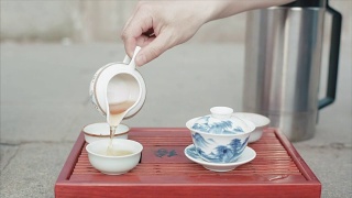 传统的中国茶道。视频。男子手套中国茶杯特写。中国的饮茶仪式。倒茶喝视频素材模板下载
