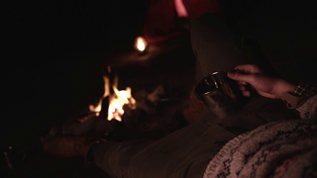 年轻人晚上在篝火旁休息