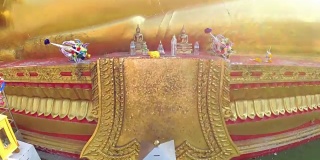 一尊巨大的金色佛像对着泰国寺庙的蓝天。芭堤雅