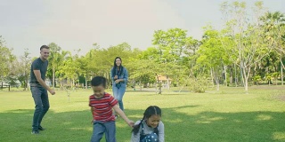 孩子和父母在公园里踢足球。缓慢的运动。