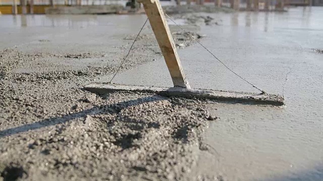 建筑顶部的工人正在粉刷混凝土地板