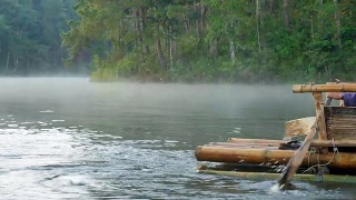 近距离观看木船划桨在竹筏通过雾漂浮在湖面上在早上在庞ung, Mae Hong Son，泰国视频素材模板下载