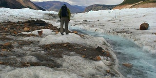 登山者在冰川上顺着水流前进