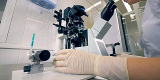 生化实验室的科学家用显微镜工作。4 k。