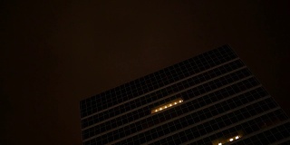 这是一个开着会议室灯的摩天大楼的夜间镜头