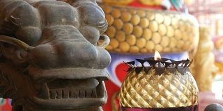 中式原创烛台。附近有一尊龙的铜像和一根燃烧的蜡烛