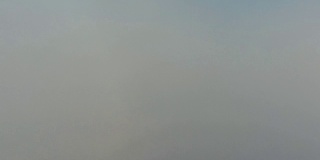 鸟瞰图。在雾中飞翔，在雾中飞翔。航空摄影机镜头。飞越云层，向着太阳。多雾的天气，从上面看。