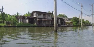 低角度:河边孤独的房子在河边的烈日下慢慢腐烂。