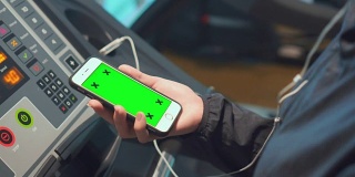 女性在健身房使用智能手机，绿色屏幕