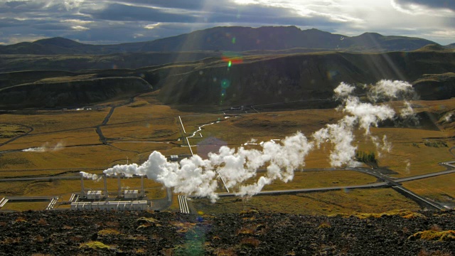 冰岛山谷景观与山脉和地热发电厂与蒸汽在阳光明媚的秋天