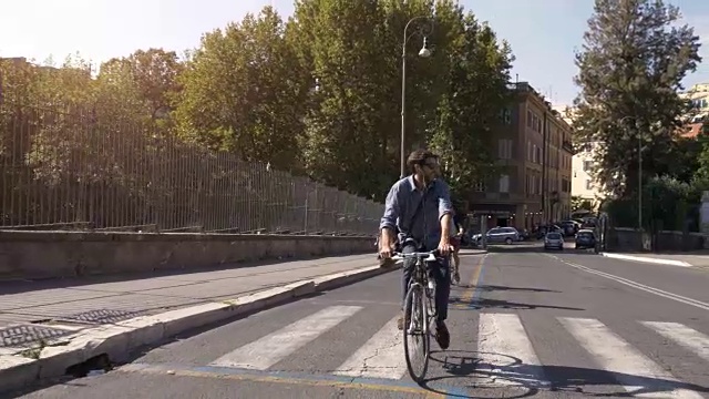 三个年轻的朋友游客在colle oppio公园骑自行车在罗马城市中心的树木在阳光明媚的日子慢镜头汽车稳定摄影机