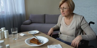 抑郁的老年妇女在养老院感到孤独，拒绝吃饭，年老