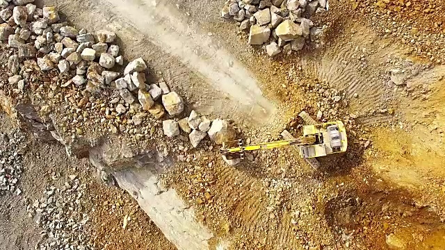 无人机在采石场的挖掘机上飞行。