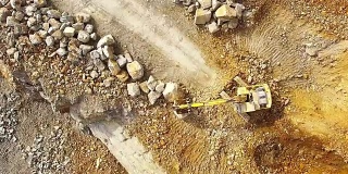 无人机在采石场的挖掘机上飞行。